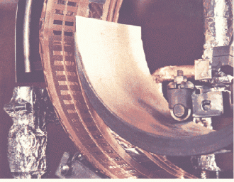 batterie-nucleari Vista di dettaglio del crogiolo, dello schermo raffreddato, del tamburo con maschere in CuBe su nastro di resina poliimmidica(Kapton). A sinistra il passante a vuoto girevole.